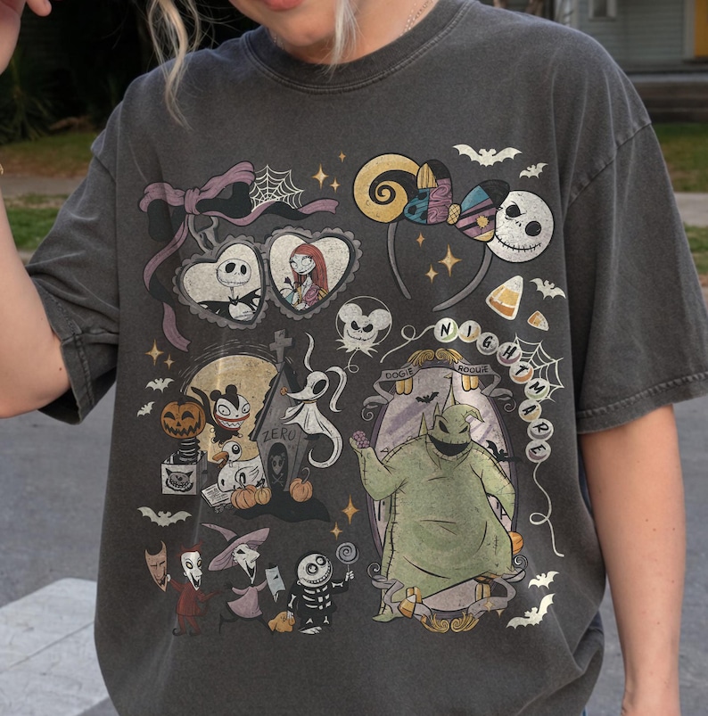 May include: A charcoal gray t-shirt featuring a collage of characters and icons from The Nightmare Before Christmas, including Jack Skellington, Sally, Oogie Boogie, Zero, and various spooky elements like pumpkins, bats, and spiderwebs.