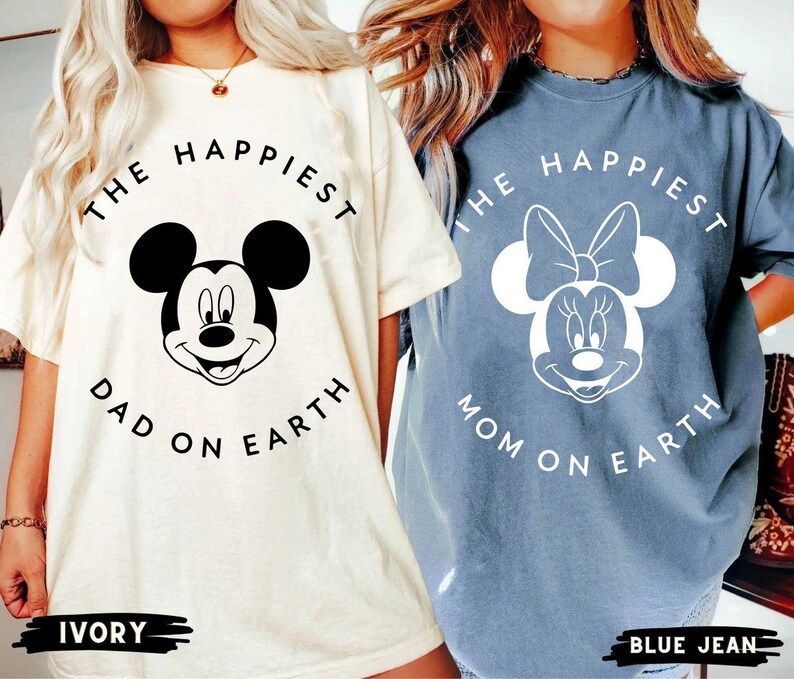 May include: Two t-shirts, one ivory and one blue jean, featuring Mickey and Minnie Mouse. The ivory shirt says "The Happiest Dad on Earth." The blue jean shirt says "The Happiest Mom on Earth."