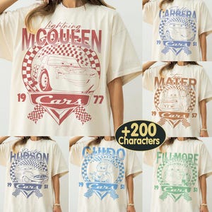 May include: Cream-colored t-shirts featuring various Cars movie characters. Designs include Lightning McQueen, Mater, Doc Hudson, Guido, Fillmore, and Sally Carrera. Each design incorporates the Cars logo and the number 51 or 77.