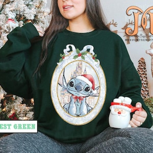 May include: Forest green sweatshirt featuring a cartoon character in a Santa hat, inside an oval frame with a castle background. The sweatshirt has the text "FOREST GREEN" at the bottom. A Santa mug is held in the hand.