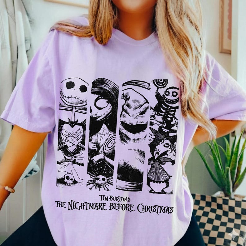 May include: A light purple t-shirt featuring a black graphic print of characters from Tim Burton's The Nightmare Before Christmas. The design consists of four vertical panels displaying Jack Skellington, Sally, Oogie Boogie, and other figures.