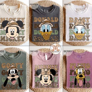 May include: Ten different color t-shirts with a Disney character graphic and text. The shirts feature Mickey Mouse, Donald Duck, Daisy Duck, Goofy, and Minnie Mouse. The text on the shirts includes "Mickey", "Donald", "Daisy", "Goofy", and "Minnie".