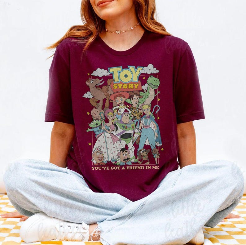Puede incluir: Camiseta burdeos con un gr&aacute;fico colorido de personajes de la pel&iacute;cula de animaci&oacute;n "Toy Story". El dise&ntilde;o incluye el t&iacute;tulo de la pel&iacute;cula en amarillo y la frase "You've Got a Friend in Me". La camiseta es de cuello redondo y manga corta.