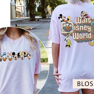 Puede incluir: Camiseta rosa con un gr&aacute;fico de Mickey Mouse y otros personajes de Disney. El texto "Walt Disney World" est&aacute; impreso en la parte posterior de la camiseta.