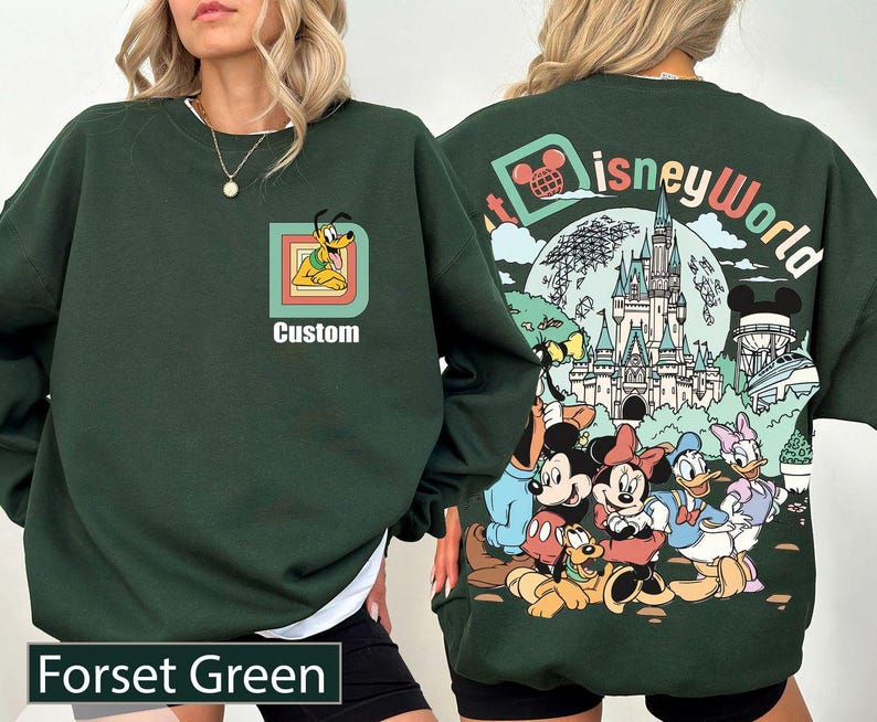 May include: Dark green sweatshirt featuring a Pluto graphic and the word "Custom". The back displays a Disney World design with Mickey, Minnie, Donald, and Daisy Duck. The sweatshirt is labelled "Forset Green".