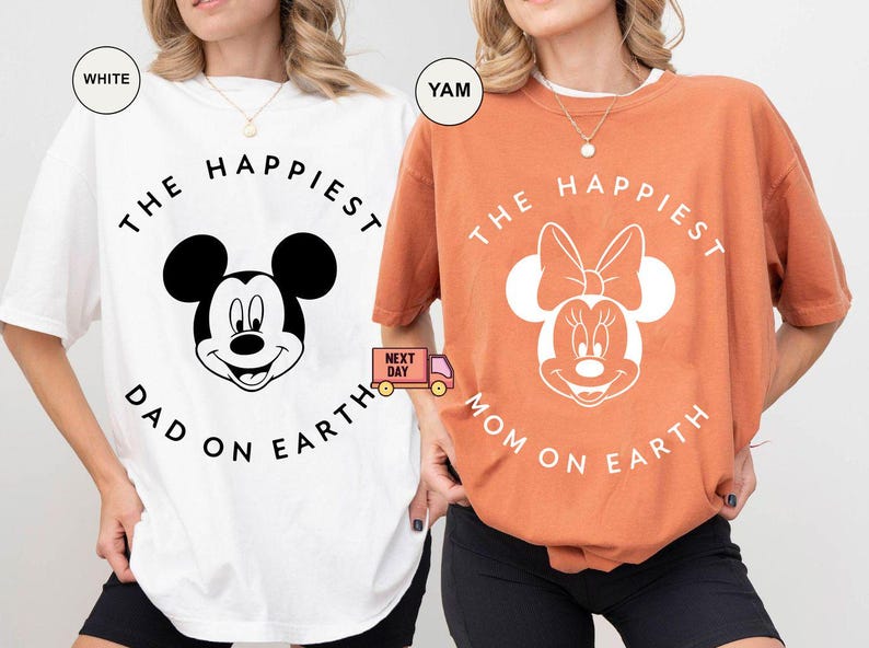 May include: Two t-shirts, one white and one orange, featuring Disney characters. The white shirt has Mickey Mouse with "THE HAPPIEST DAD ON EARTH" text. The orange shirt has Minnie Mouse with "THE HAPPIEST MOM ON EARTH" text.