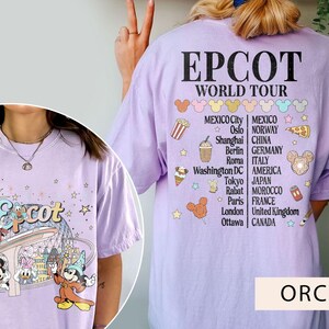 May include: A purple t-shirt featuring a graphic of Mickey Mouse and friends at Epcot. The shirt also displays the text "Epcot World Tour" and a list of cities from around the world.