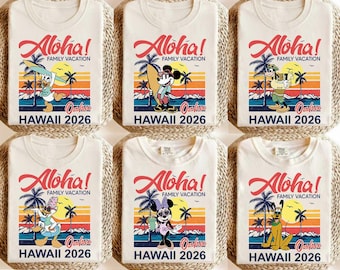 May include: Six off-white t-shirts with a colorful Hawaiian-themed graphic. The design includes the word "Aloha!" in red script, palm trees, and cartoon characters. The text "HAWAII 2026" is also visible.
