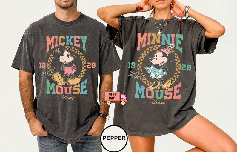 May include: Two black t-shirts with a vintage-style graphic of Mickey Mouse and Minnie Mouse. The shirts feature the text "Mickey Mouse" and "Minnie Mouse" in a rainbow color scheme.