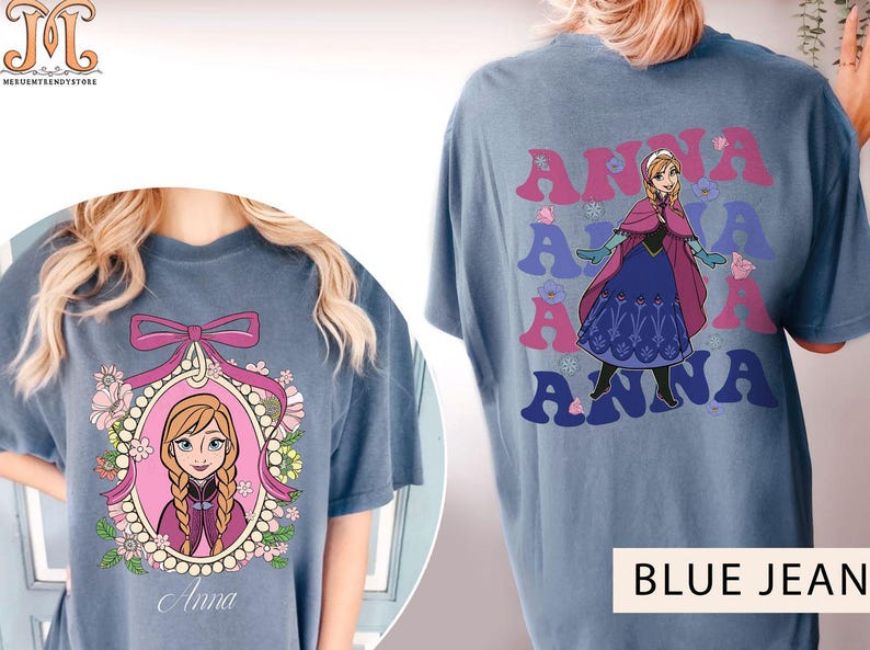 May include: Two blue jean t-shirts featuring a cartoon image of Anna from Frozen. One shirt has a single image of Anna in a pink frame with flowers. The other shirt has a repeated image of Anna with the word "Anna" in a retro font.