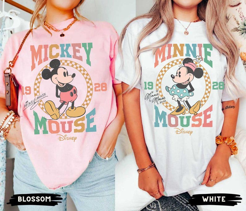 May include: Two t-shirts with a retro design featuring Mickey Mouse and Minnie Mouse. The Mickey Mouse shirt is pink with the text "Mickey Mouse" and "Disney" in a vintage font. The Minnie Mouse shirt is white with the text "Minnie Mouse" and "Disney" in a vintage font.