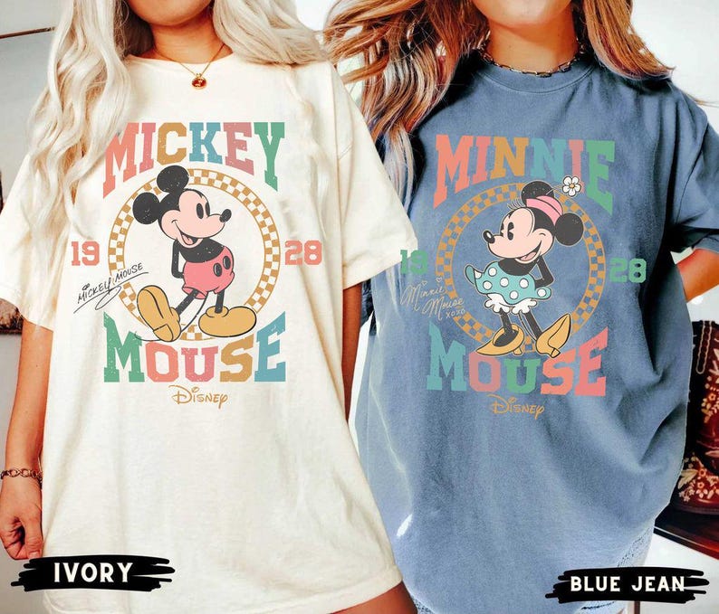 May include: Two oversized t-shirts with a vintage Mickey Mouse and Minnie Mouse design. The Mickey Mouse shirt is ivory with a red, yellow, blue, and green color scheme. The Minnie Mouse shirt is blue jean with a red, yellow, blue, and green color scheme. Both shirts feature the text "Mickey Mouse" and "Minnie Mouse" with the word "Mouse" in a rainbow color scheme.