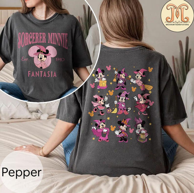 May include: A gray t-shirt with a pink and black graphic of Minnie Mouse as a sorceress. The front of the shirt says "Sorcerer Minnie Est. 1940 Fantasia". The back of the shirt has a pattern of nine Minnie Mouse sorceresses in different poses.
