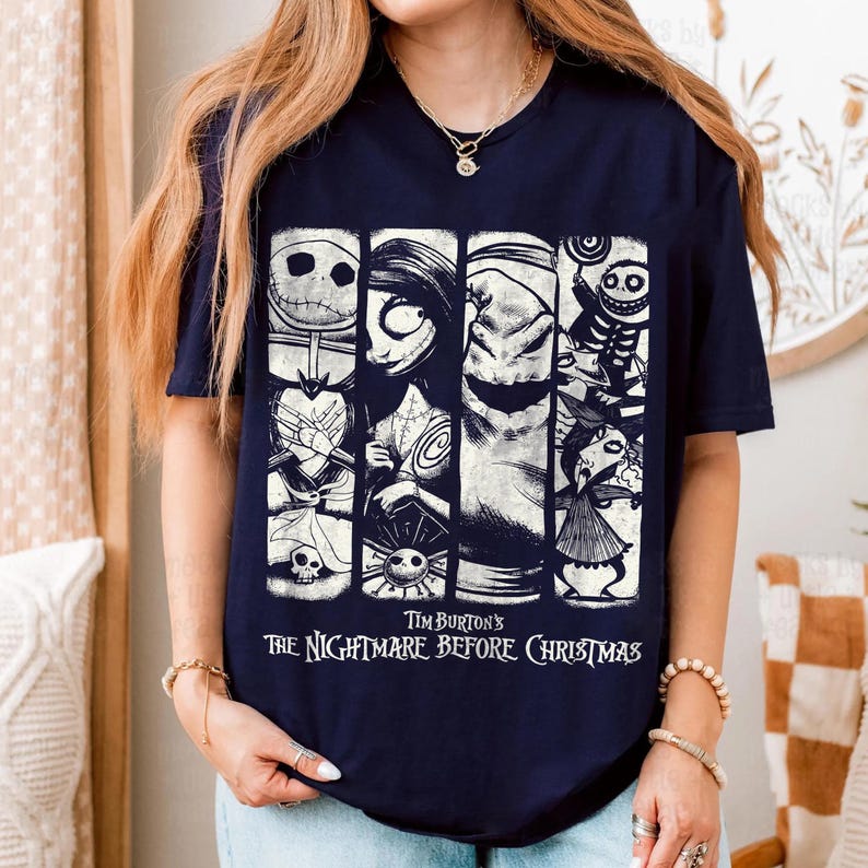 May include: A navy blue short-sleeve t-shirt featuring a white graphic print of characters from Tim Burton's The Nightmare Before Christmas. The design consists of four vertical panels displaying Jack Skellington, Sally, Oogie Boogie, and Lock, Shock, and Barrel.