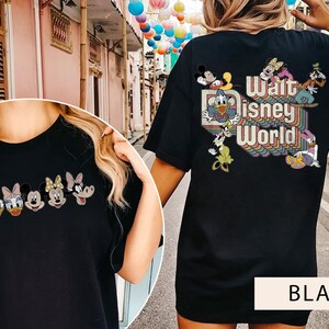 Puede incluir: Camiseta negra con un gr&aacute;fico de Mickey Mouse y sus amigos en la parte delantera y "Walt Disney World" con un dise&ntilde;o de arco&iacute;ris en la parte posterior.