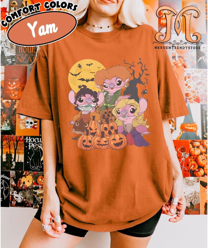 May include: Orange Comfort Colors t-shirt with a Halloween-themed graphic. The graphic features cartoon characters, pumpkins, a full moon, bats, and a spooky tree. The shirt has the word "Yam" in a brown oval.