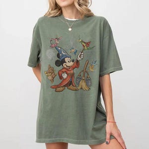 K&ouml;nnte beinhalten: Eine wei&szlig;e Keramik-Tasse mit schwarzem Henkel und dem Text "But First, Coffee" in fetter, schwarzer Schrift. Die Tasse steht vor einem verschwommenen Hintergrund, der ihr klares Design hervorhebt.