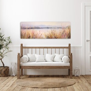a white couch sitting in a living room next to a painting