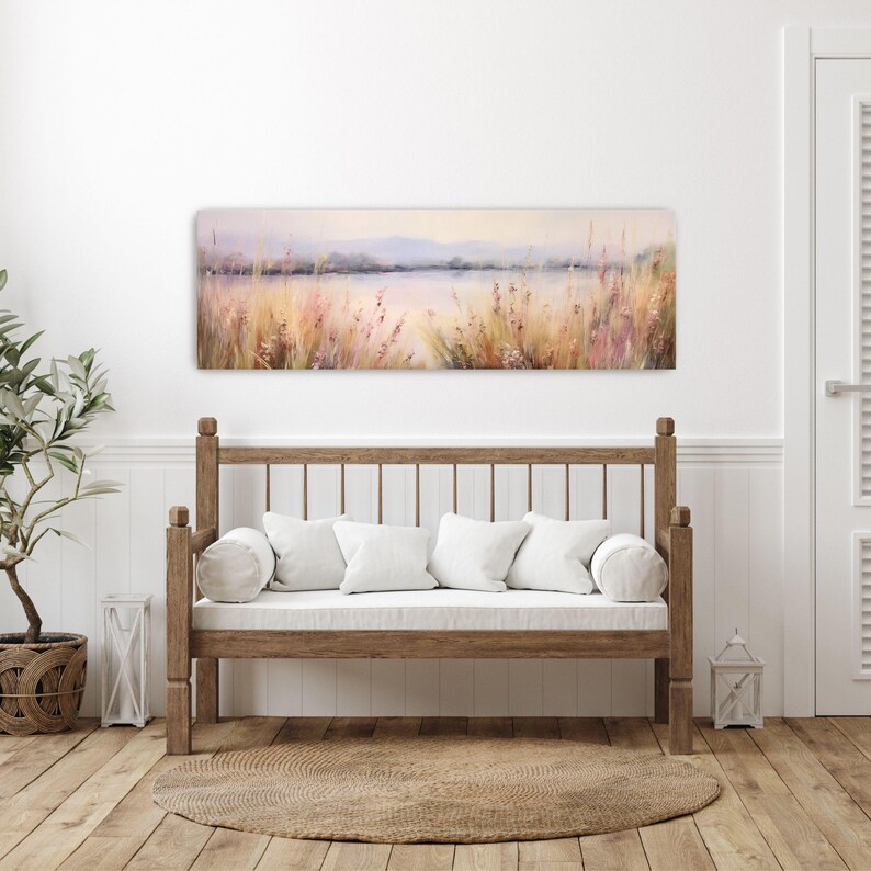a white couch sitting in a living room next to a painting