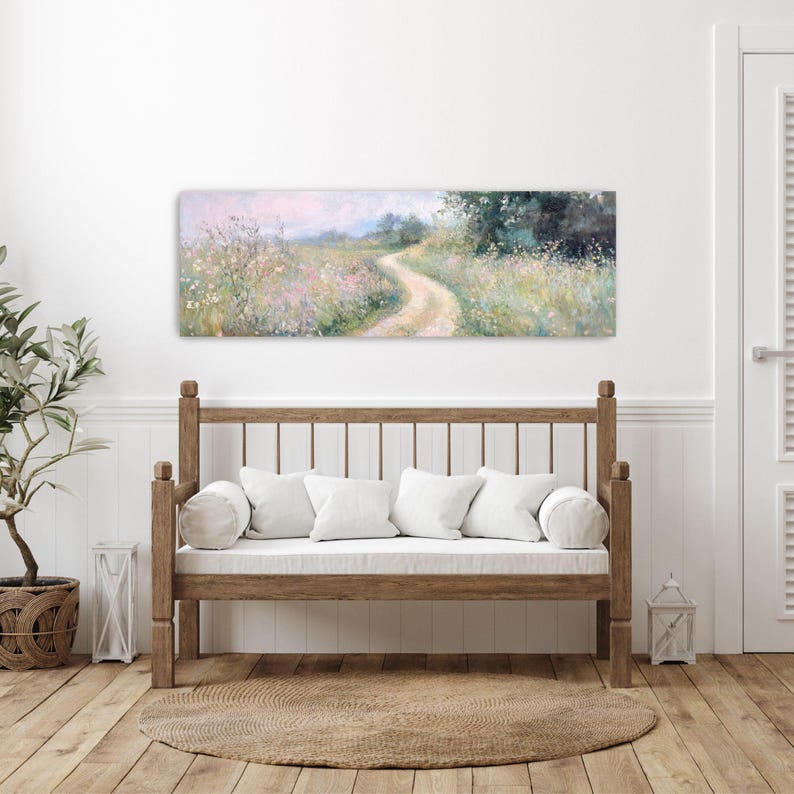 a white couch sitting in a living room next to a painting
