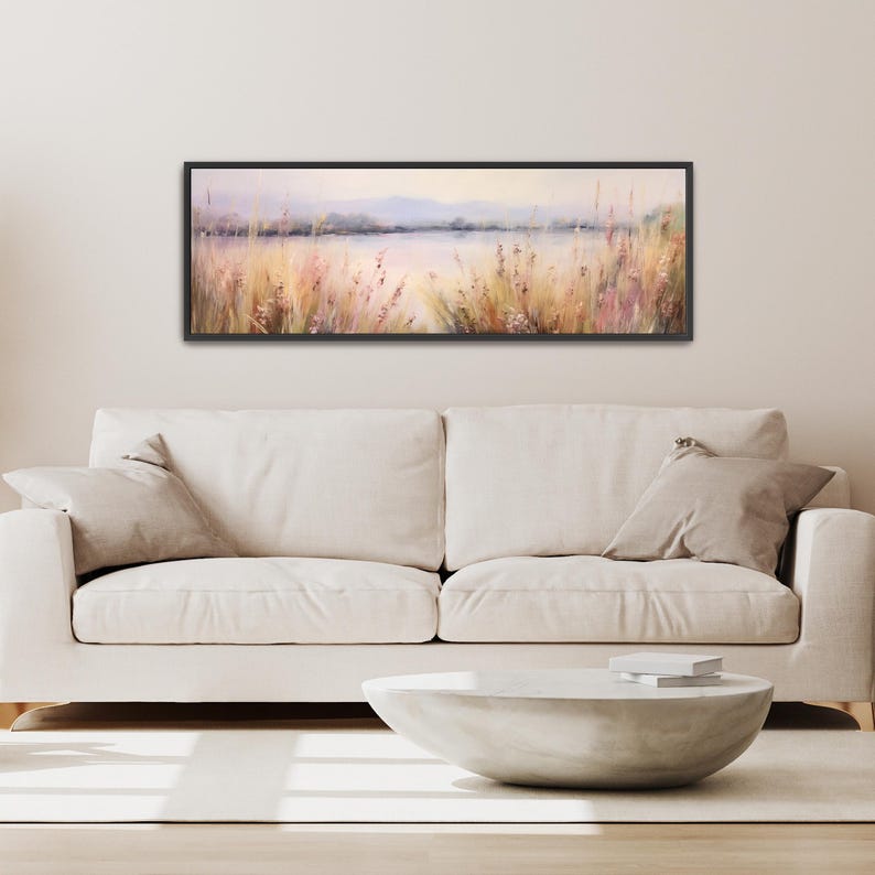 a living room with a white couch and a painting on the wall