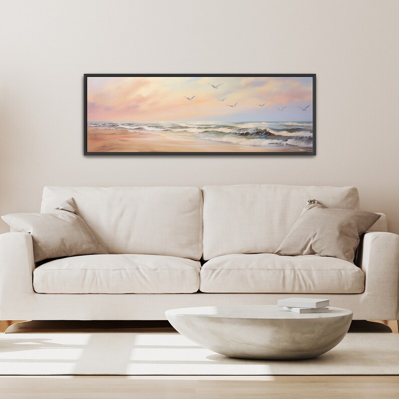 a living room with a white couch and a painting on the wall