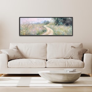 a living room with a white couch and a painting on the wall