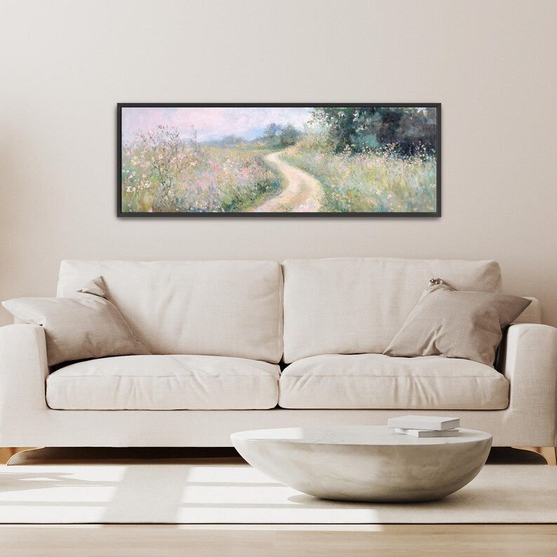 a living room with a white couch and a painting on the wall