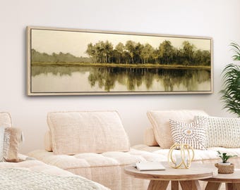 May include: A rectangular landscape painting featuring a serene lake scene with trees reflected in the water. The artwork is framed in a light-colored wooden frame. The color palette includes muted greens, browns, and beige tones, creating a calming atmosphere.