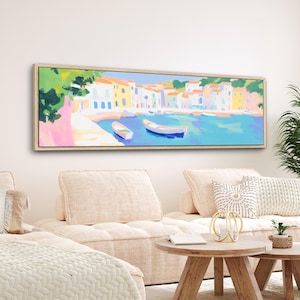 Puede incluir: Una pintura larga y horizontal de un pueblo costero colorido con barcos en el agua. Los edificios están pintados en tonos de amarillo, azul, rosa y blanco. El agua es de un azul turquesa brillante.