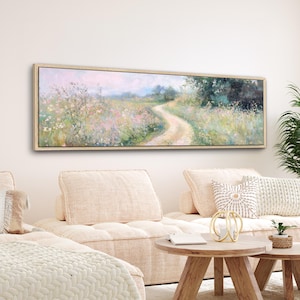a living room with a white couch and a painting on the wall