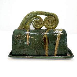 Mantequera hecha a mano con diseño de helecho y brotes de helecho.