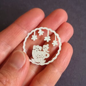Béret à pompons fille et chien dans une tasse, Mini oeuvre d&#39;art originale en papier découpé à la main de la taille d&#39;une pièce de monnaie, oeuvre d&#39;art japonaise Kiri-e découpée dans du papier, 1,25 po. (30 mm) de diamètre