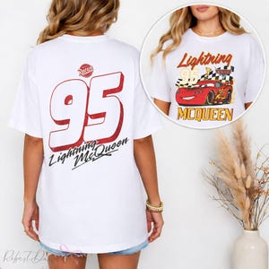 May include: White t-shirt featuring a large red number 95 with a distressed effect and the words "Lightning McQueen" in black script. The shirt also has a small graphic of Lightning McQueen on the front.
