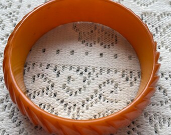Carved Butterscotch Bakelite Bangle Bracelet 3/4” wide 3” in diameter.  It has been tested with simichrome polish and passed the test.
