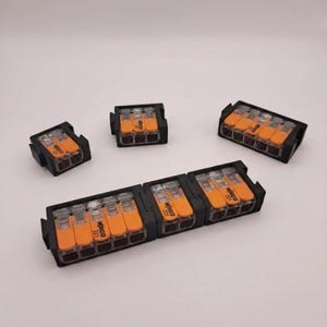 May include: Several black and orange electrical wire connectors are displayed against a white background. The connectors are labeled "WAGO 221". The connectors are used for connecting electrical wires.