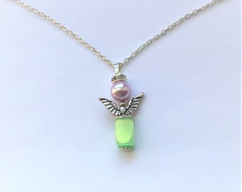 May include: A silver chain necklace with a green glass bead and a silver angel charm with a pink pearl on top.