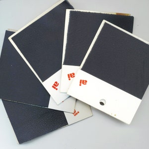 May include: Five black fabric swatches with white borders and the word "ai!" printed in red on each.