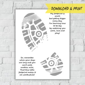 Op de afbeelding: Een witte print met twee grijze voetafdrukken en tekst. De tekst luidt: "Mijn voetafdruk is klein, maar wordt elke dag groter. Ik leer hoe ik groot kan worden door naar je te kijken werken, liefhebben en spelen!" en "Dus, onthoud wanneer je dagen lang zijn en je geen mijl meer kunt lopen, dat deze kleine voetafdruk het allemaal de moeite waard maakt!"