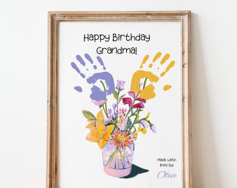 May include: A framed print with a handprint art design. The print features a bouquet of flowers in a vase with the text "Happy Birthday Grandma!" and "Made with love by Olive".