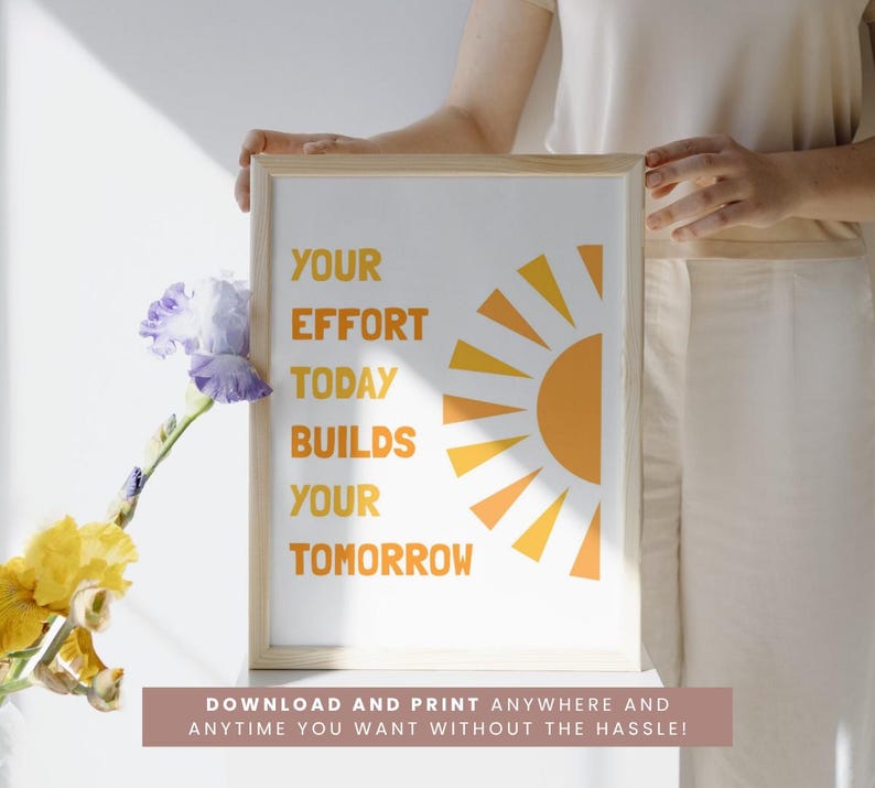 May include: A framed print with the text "YOUR EFFORT TODAY BUILDS YOUR TOMORROW" in orange. The design includes a stylized orange sun. The bottom of the frame has the text "DOWNLOAD AND PRINT ANYWHERE AND ANYTIME YOU WANT WITHOUT THE HASSLE!"