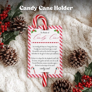 May include: A candy cane holder with a red and white striped design. The holder features the text "The Wonder of Candy Cane" and a poem. The image includes a candy cane, holly, and pinecones, evoking a festive Christmas theme.