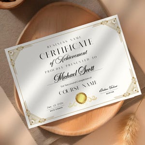 May include: A white certificate with gold accents and a gold seal. The text reads "BUSINESS NAME CERTIFICATE of Achievement PROUDLY PRESENTED TO Michael Scott For Successful Completion of COURSE NAME Arden Valiur MENTOR Jan 12 2024 DATE SIGNED"