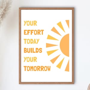 May include: A framed print with the text "YOUR EFFORT TODAY BUILDS YOUR TOMORROW" in orange, with a stylized orange sun graphic. The artwork is in a wooden frame, suitable for home or office decor.