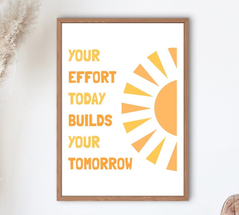 May include: A framed print with the text "YOUR EFFORT TODAY BUILDS YOUR TOMORROW" in orange, with a stylized orange sun graphic. The artwork is in a wooden frame, suitable for home or office decor.