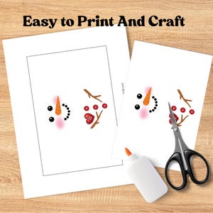 May include: Two white paper printouts with snowman face elements, including carrot noses, black dot eyes, and twig arms. The text "Easy to Print And Craft" is at the top. A bottle of glue and scissors are on a wooden surface.