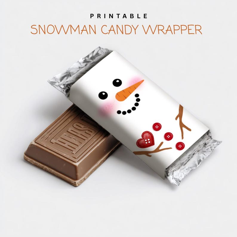 May include: A white candy wrapper with a snowman face design, featuring black eyes, an orange carrot nose, and a black dotted smile. The wrapper is next to a brown chocolate bar. The text "PRINTABLE SNOWMAN CANDY WRAPPER" is at the top.