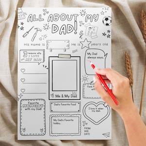 K&ouml;nnte beinhalten: Ein wei&szlig;es Ausf&uuml;llposter mit dem Text "ALL ABOUT MY DAD!" und verschiedenen Aufforderungen, darunter "His name is", "3 Gr&uuml;nde, warum ich meinen Vater liebe" und "Me & My Dad". Eine Hand mit einem roten Bleistift schreibt auf das Poster.