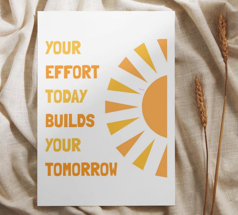 May include: A white poster with the text "YOUR EFFORT TODAY BUILDS YOUR TOMORROW" in orange. A stylized orange and yellow sun graphic is on the right. Two stalks of wheat are on the right side of the poster.