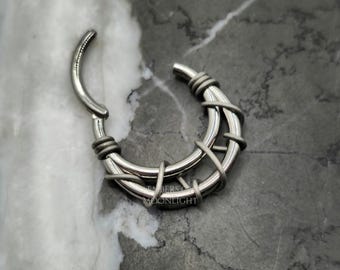 May include: A silver septum ring with a wire cage design. The ring is made of surgical steel and is suitable for piercings.